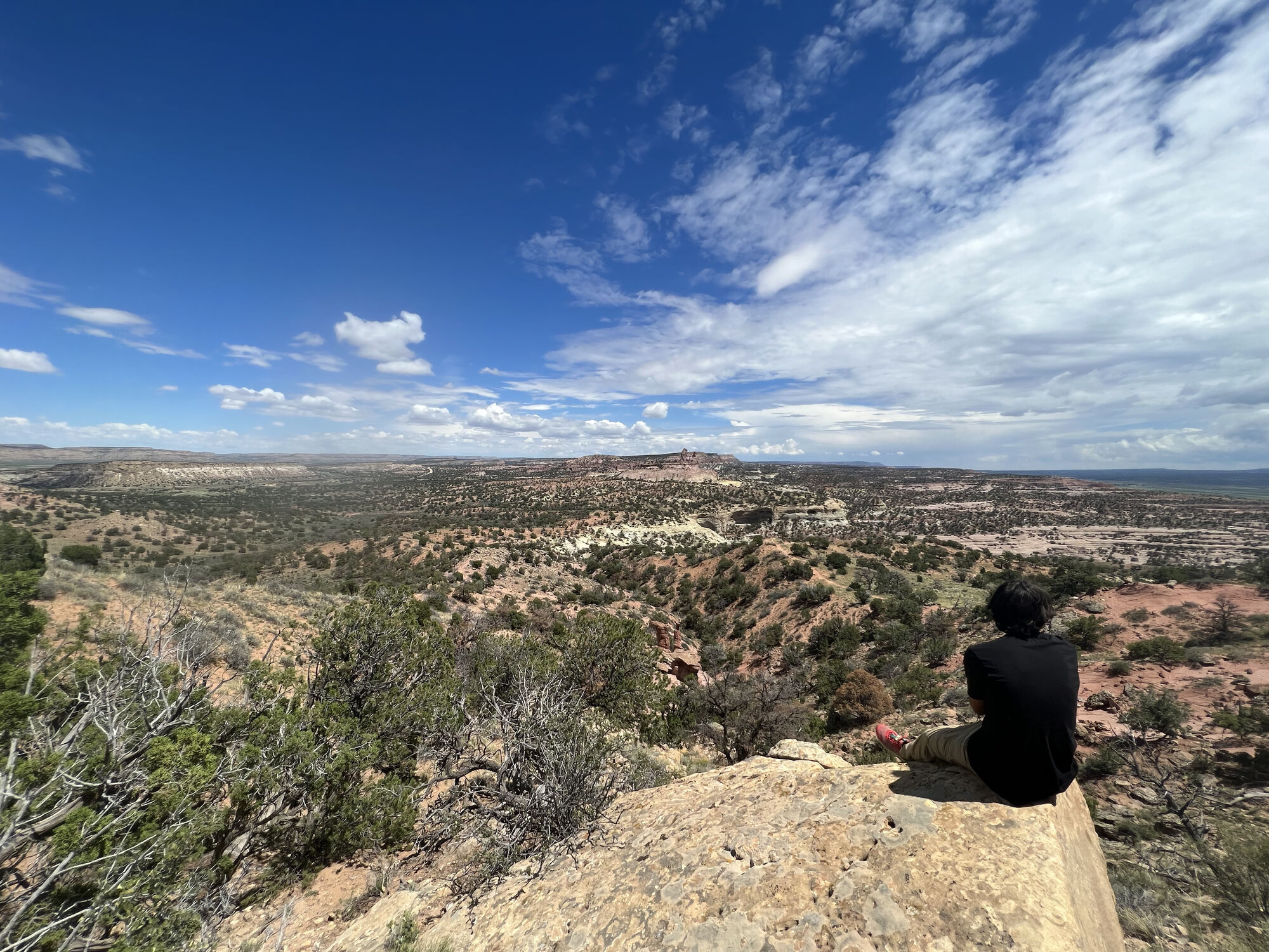 Jules sitting at the edge of a vast canyon at the end of his cycling journey